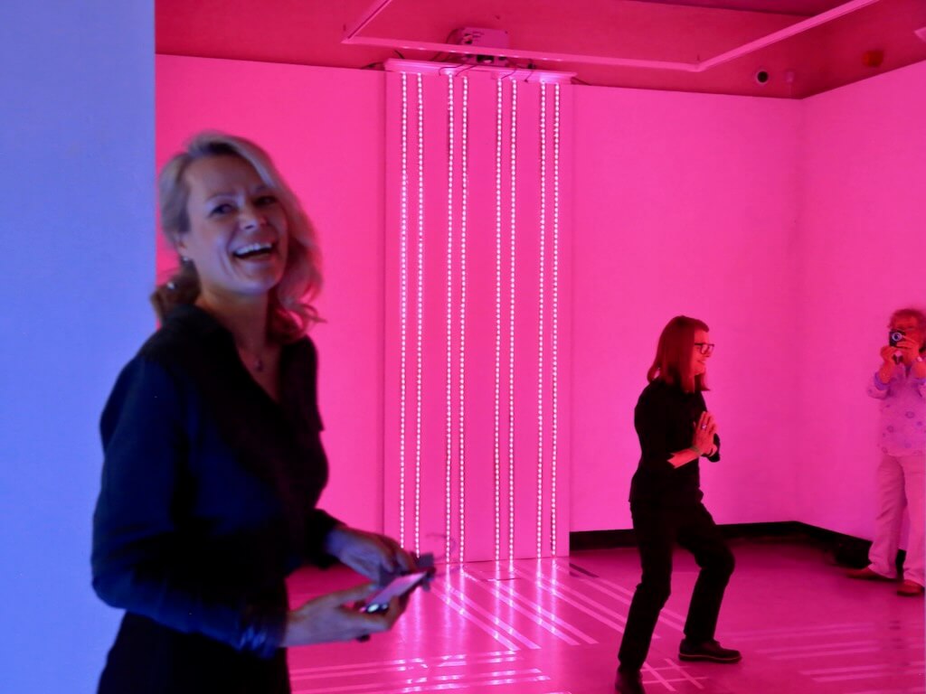 Happy faces enjoy vibrant pink light patterns.