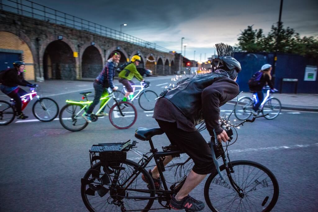 Cyclists race through the streets, activating the lights in their bikes.