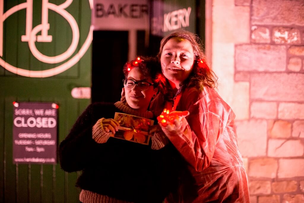 Two women happily pose with their red lights.