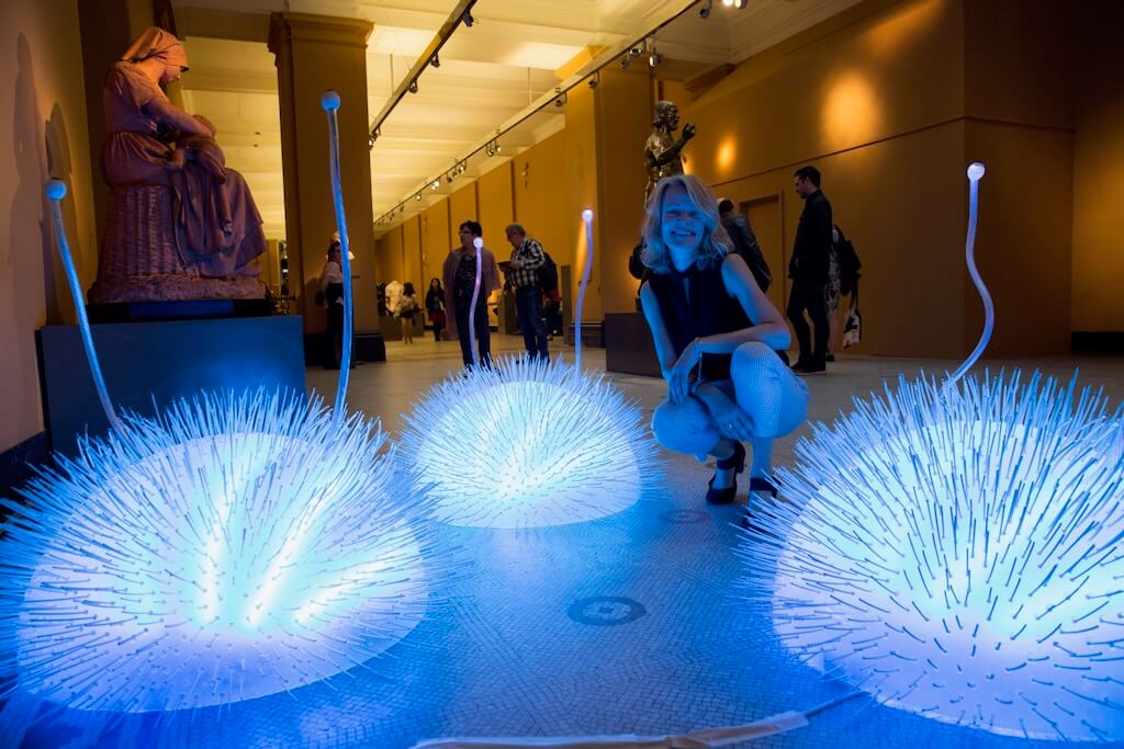 Tine Bech proudly poses with her glowing creatures created for Chromatic Play.