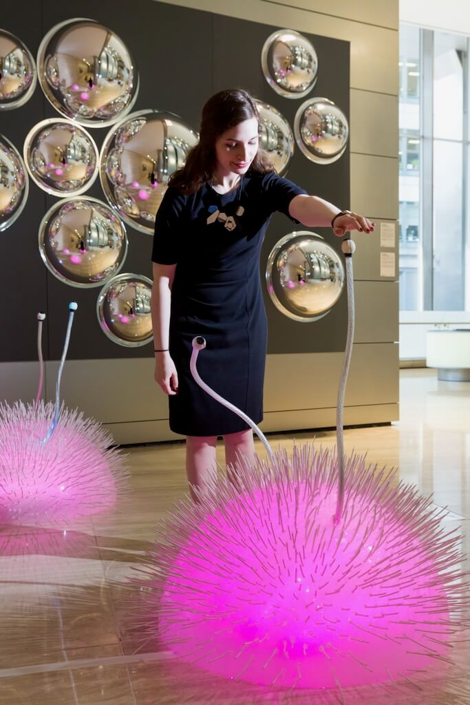 A woman activates new colours to emanate from spiky creatures.