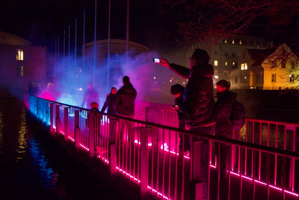 The public wraps up warmly to go out at night and experience Tine's light art to the full effect.