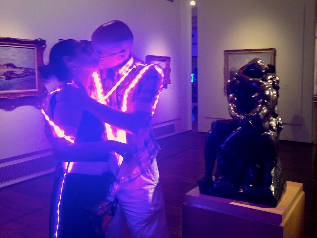 Two players participating in a game recreate a statue scene from the gallery the game is taking place in.