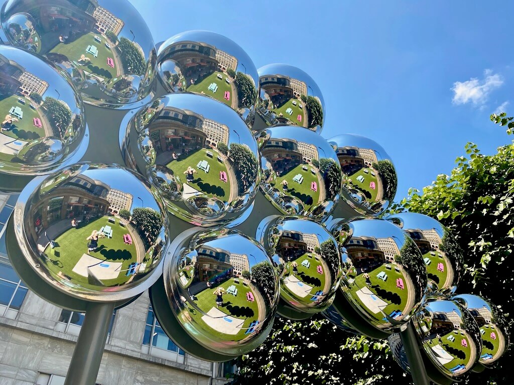 Bright blue skies and colourful picnic benches are reflected by Tine's metallic cloud.