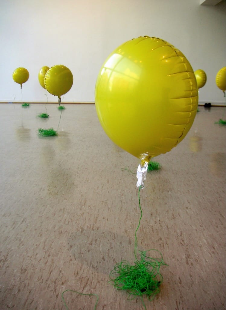 A field of movement-sensitive balloons float across a linoleum floor.