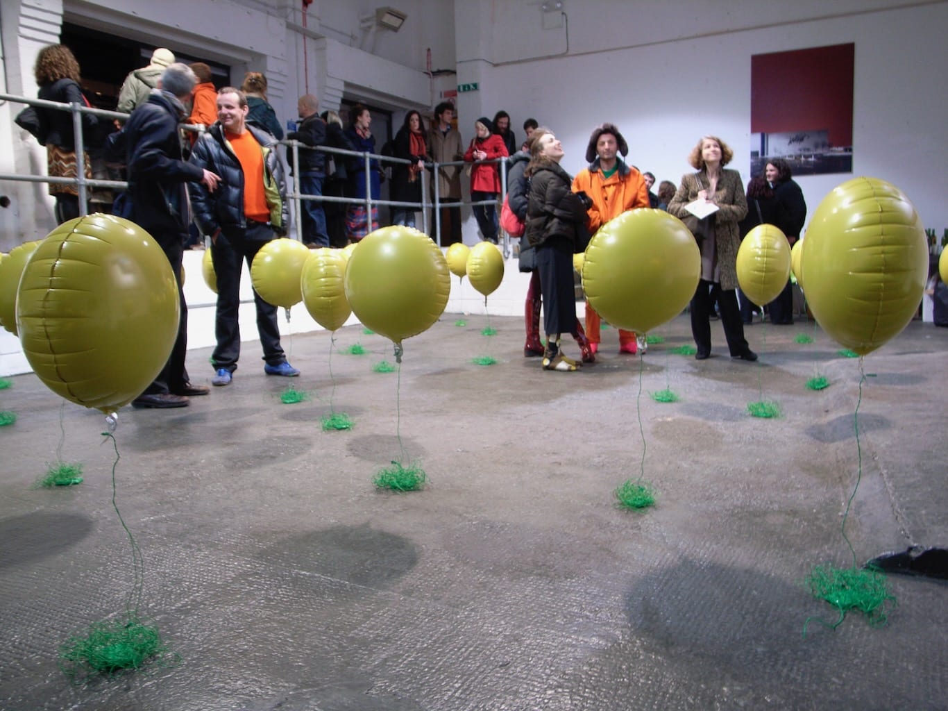 A field of floating yellow balloons intrigue exhibition visitors.