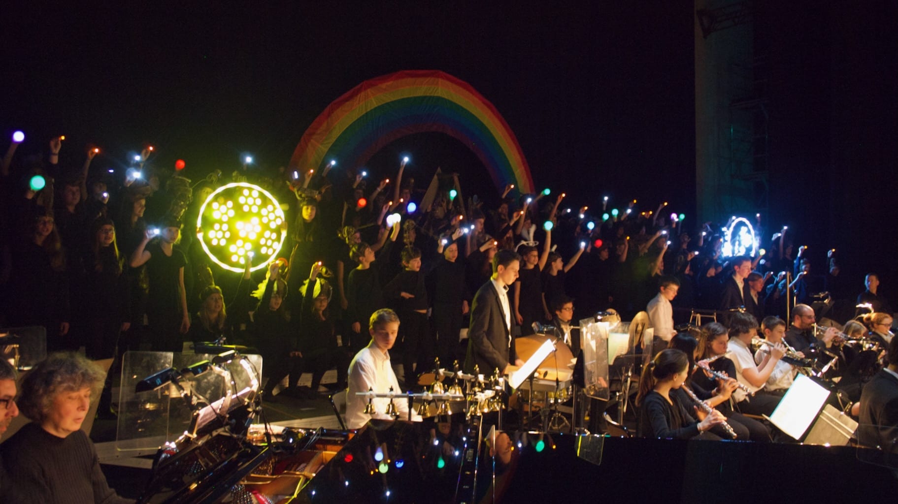 A theatre is illuminated with handheld lights, creating beautiful shapes and patterns.