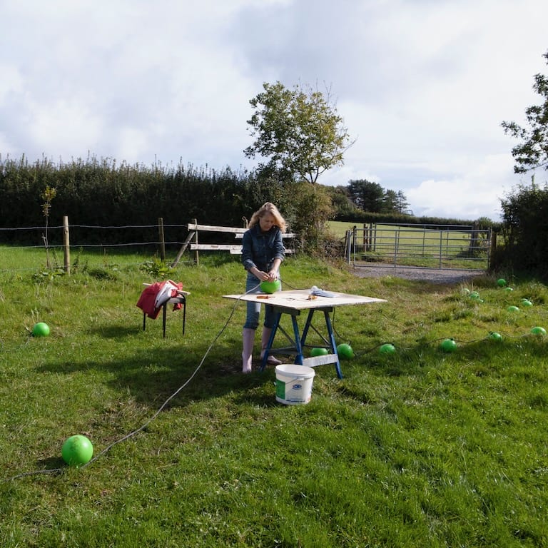 Tine Bech works hard connecting many buoys together for a new artwork in Swansea.